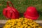 Red women`s hat and bag lying on green grass next to yellow flowers