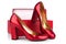 Red women`s high-heeled shoes patent leather and red box on a white background  close up