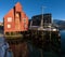 Red wooden boathouse in the docks of the harbor of TromsÃ¸ on a sunny morning