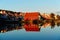 Red wooden cabins at campsite by the fjord