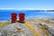 Red wooden chairs overlooking the ocean