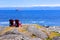 Red wooden chairs overlooking the ocean