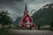 Red wooden church of Olden in the Nordfjord fjord in summer in Norway