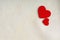 Red wooden decorative hearts on white cloth background.