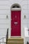 Red Wooden Entrance Door to residential building in London. Typical door in the English style.