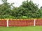 Red wooden fence around garden, Lithuania