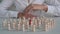 Red wooden figure in row of white identical wooden figures