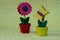 red wooden flower with leaves and a yellow butterfly on a same colored planters