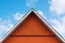 Red wooden gable under cloudy sky