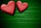 Red Wooden Hearts on Green Wood Background