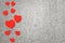 Red wooden hearts on grey cement background, festive background