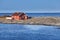 Red wooden house on rocky island. Norway