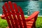 A red wooden lawn chair on the waterfront riverwalk on a sunny day
