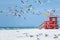 Red wooden lifeguard hut on an empty morning beach