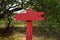 Red, wooden pointer, arrow, indicates the direction in the forest