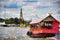 A red wooden traditional boat with tourist is crossing the Chao Phraya River towards the famous and amazing Wat Arun ancient Thai
