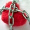 Red wool heart locked with metal chain on white bed sheet