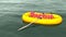 Red word rescue in yellow rubber boat on the ocean