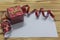 red wrapped gift box, red ribbon, blank. Holiday greeting card on vintage rustic wooden background, copy space top view