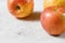 Red and yellow apples kiku variety on white board, closeup whit space for text down left