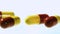 Red and yellow capsule tablets falling and bouncing close up