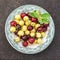 Red and yellow cherries in dark ceramic bowls on a dark background. Top view