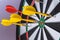 Red and yellow dart arrows hitting in the target center of dartboard. Success hitting target aim goal achievement concept