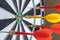 Red and yellow dart arrows hitting in the target center of dartboard. Success hitting target aim goal achievement concept