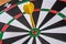 Red and yellow dart arrows hitting in the target center of dartboard. Success hitting target aim goal achievement concept