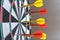 Red and yellow dart arrows hitting in the target center of dartboard. Success hitting target aim goal achievement concept