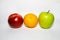 Red yellow, green apple and orange on a white background, as a traffic light