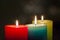 Red, yellow and green colourful candles with blurred bokeh background. Christmas and New Year copy space.