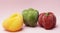 red yellow and green pepper on a pink background. vegetable concept