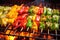 red, yellow and green skewers of vegetables roasting on a flame