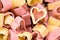 Red and yellow heart shaped pasta, top view, food background, cl