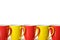 Red and yellow mugs in a row White background