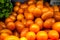 Red yellow oval tomatoes on a shelf in a store with a green salad