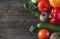 Red and yellow peppers, beetroot, tomato, green cucumbers, garlic,  onions, spinach on a brown wooden  top view, fresh vegetables