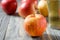 Red yellow ripe apple Royal Gala with water drops closeup on blurred background with apples and glass of cider or sparkling juice