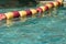 Red and yellow swimming safety buoys in a row for children`s protection in outdoor pool for deep end safety