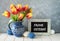 Red-yellow tulips in blue ceramic pitcher with Easter eggs and a