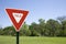 Red Yield Sign in a Green Landscape, Blue Sky