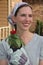 Red Zinnia being held by smiling woman.