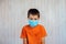 Red zone regions. Little boy in a medical mask looking at the camera. Sad child in a protective mask against coronavirus Covid-19