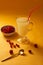 Redcurrants, glass cup with serum on a yellow background