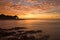 A reddish sunset in the sea with the sun in the background