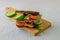 Redfish bread sandwich with cucumber and tomatoes for breakfast laying on a wooden board