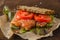 Redfish bread snack with salad and tomatoes laying on a kraft paper