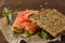 Redfish bread snack with salad and tomatoes laying on a rustic board