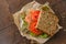 Redfish sandwich with salad and tomatoes laying on a kraft paper